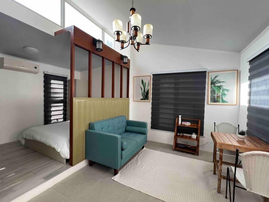 a living room with a blue chair and a bed at Romantic Cabin Retreat with Garden View and Free Parking in Amadeo