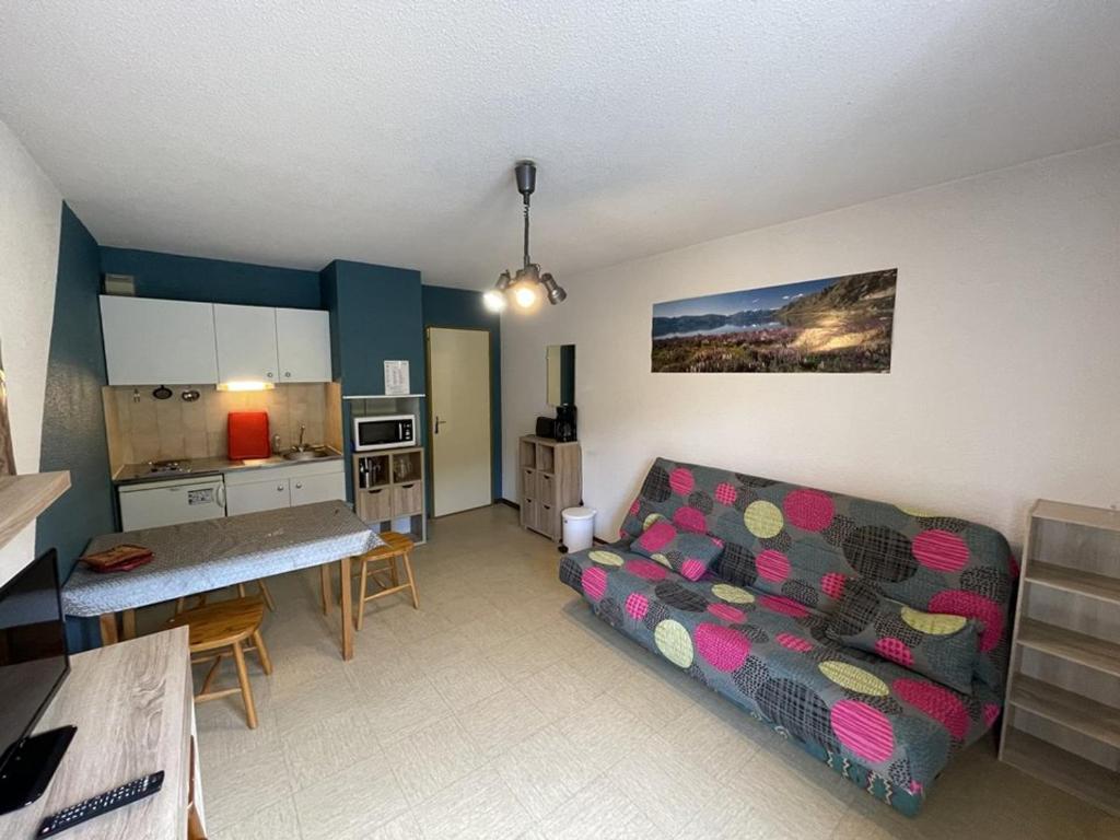 un salon avec un canapé et une cuisine dans l'établissement Charmant studio exposé plein sud face aux pistes, idéal pour 4 pers., animaux bienvenus - FR-1-787-62, à Laveissière