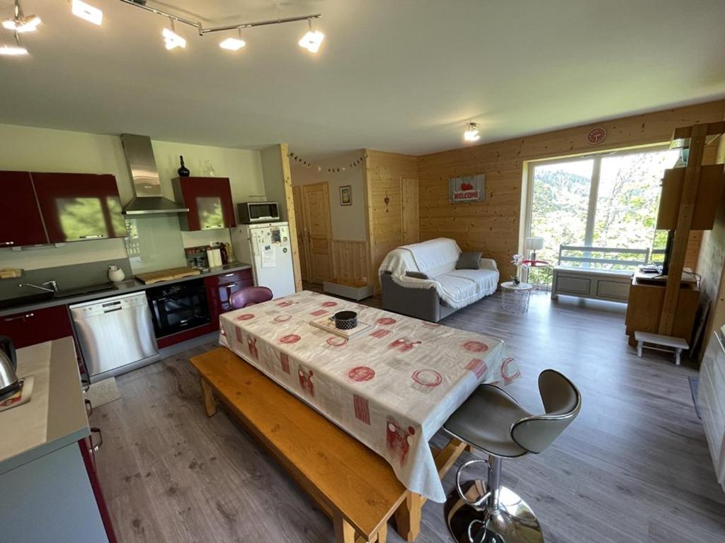 une cuisine et un salon avec une table dans une pièce dans l'établissement **Appartement T3 avec Terrasse, Parking et Proche Pistes** - FR-1-787-48, à Laveissière