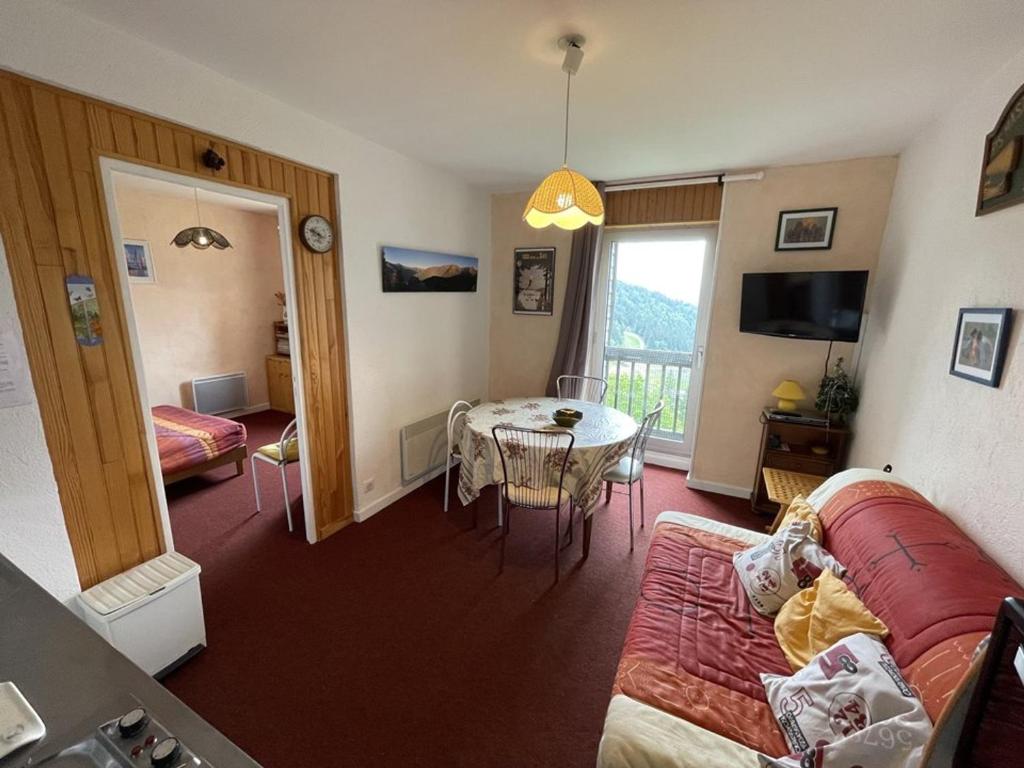 ein Wohnzimmer mit Sofa und Tisch in der Unterkunft Charmant T2 près des pistes avec équipement bébé, casier à skis, animaux non admis - FR-1-787-68 in Laveissière