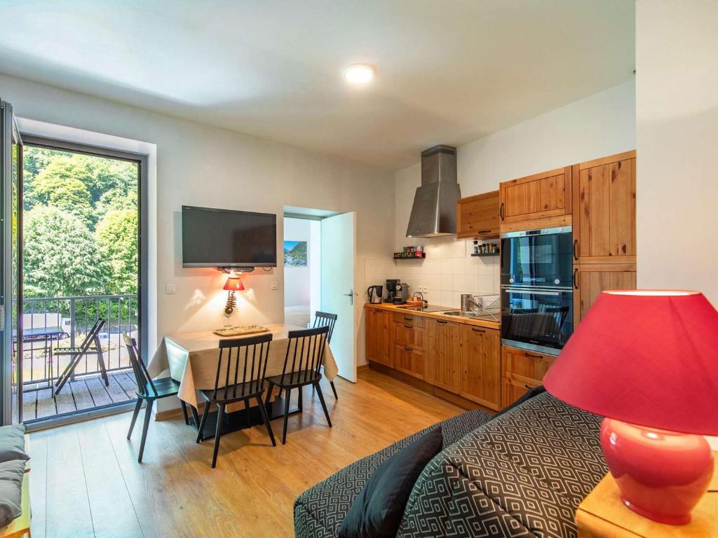 - un salon avec une cuisine et une table avec des chaises dans l'établissement Appartement cosy à Cauterets avec balcon, centre-ville, 2 chambres, pour 4 à 6 personnes - FR-1-401-296, à Cauterets