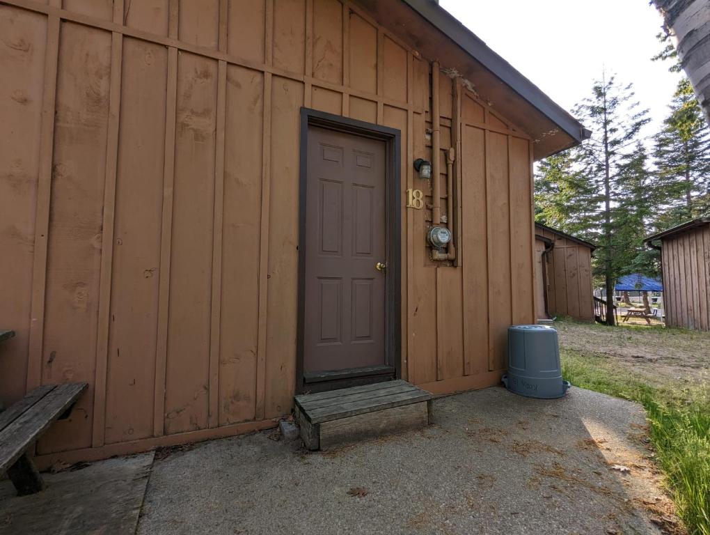 una porta su un edificio con una panchina accanto di Tiny Wood Cottage 18 a Wasaga Beach