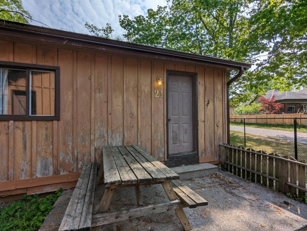 una panchina di legno seduta di fronte a una cabina di Tiny Wood Cottage 21 a Wasaga Beach