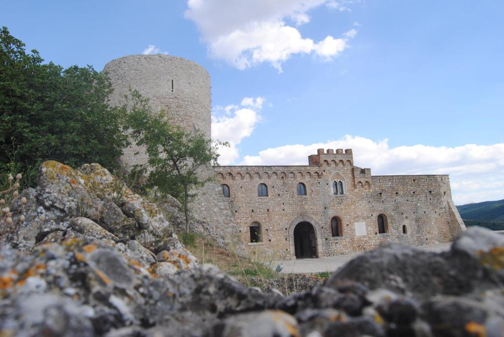 un grand bâtiment en pierre avec une tour sur une colline dans l'établissement Residenza Ducale, à Bovino