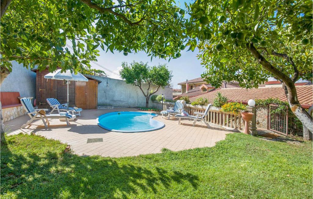 a backyard with a swimming pool and chairs and a tree at Villa Edvige in Nocera Terinese