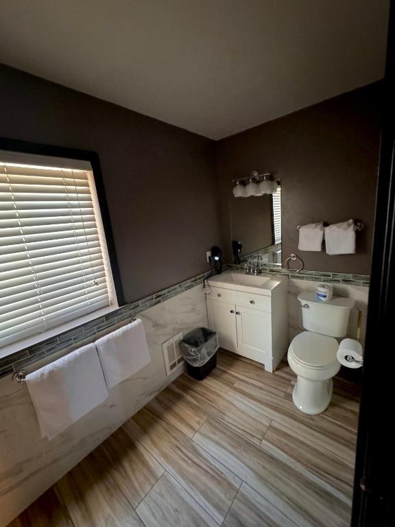 a bathroom with a toilet and a sink and a mirror at Cascade Lodge in Bend