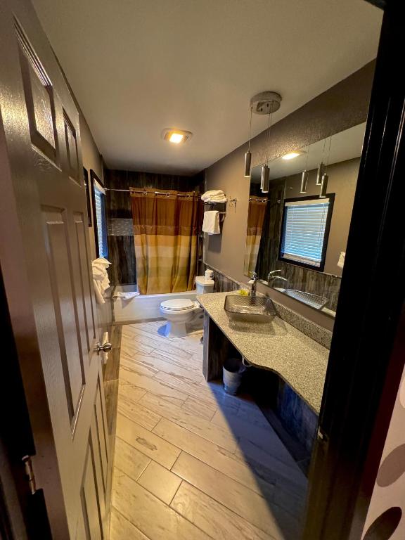 a bathroom with two sinks and a toilet and a window at Cascade Lodge in Bend