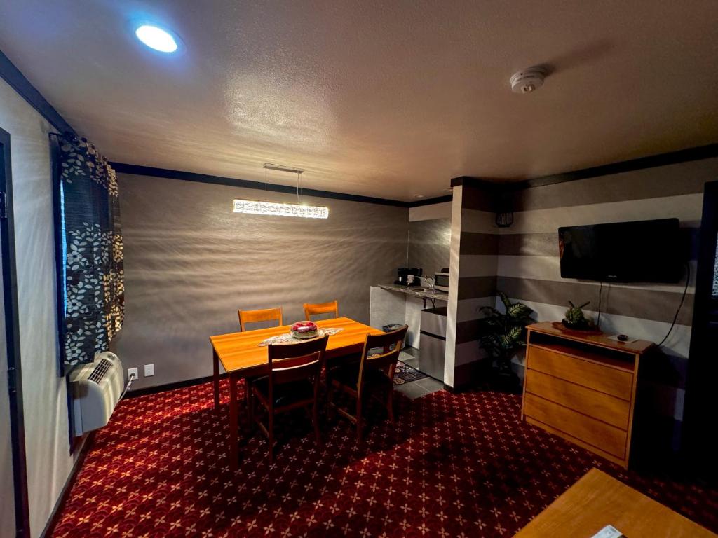 a dining room with a table and chairs and a television at Cascade Lodge in Bend