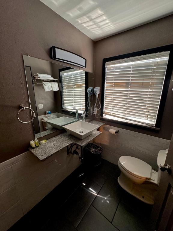 a bathroom with a sink and a toilet and a window at Cascade Lodge in Bend