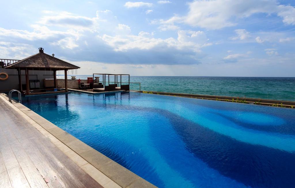a swimming pool with the ocean in the background at Hotel on The Rock in Kupang