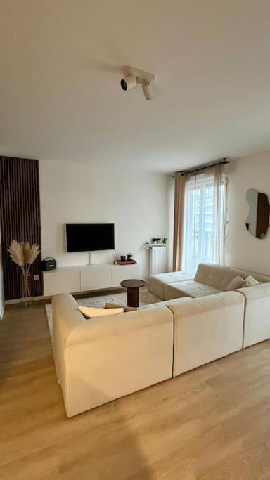 un salon avec deux canapés blancs et une télévision dans l'établissement Moderne et bien situé La Défense JO Paris 2024, à Puteaux