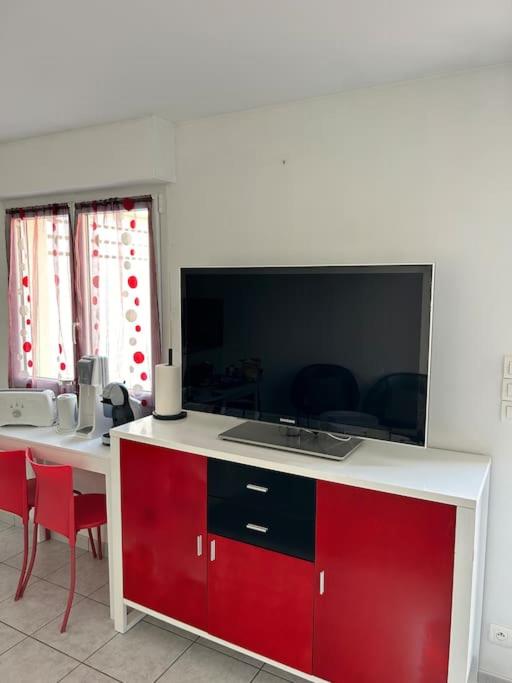 une cuisine avec un comptoir rouge et blanc et des chaises rouges dans l'établissement Hébergement Studio, à Saint-Martin-des-Noyers