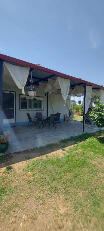 a house with tables and chairs under a tent at Aristoteles Apartments in Olympiada
