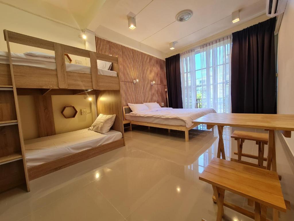 a room with two bunk beds and a table at De Chalet in Bangkok
