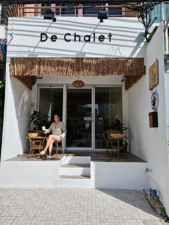 a man sitting in a chair outside of a restaurant at De Chalet in Bangkok