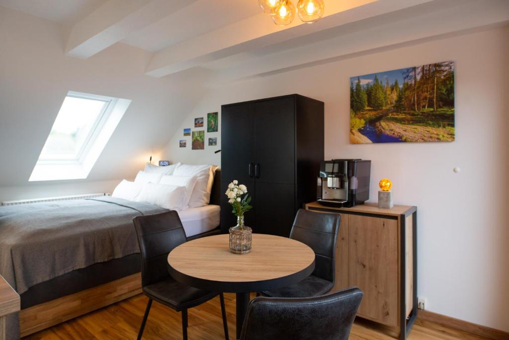 Un dormitorio con una cama y una mesa con televisión. en NEU! 9,7 Außergewöhnlich Bergblick mit Balkon Boxspringbett Kaffeevollautomat inkl Bettwäsche Handtücher #MeeneFewo de, en Bad Harzburg