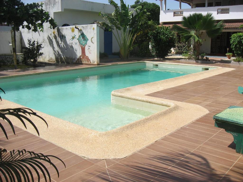 a large swimming pool in a yard with a patio at Babao in Mbour