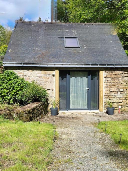une petite maison en pierre avec une fenêtre et un toit dans l'établissement Petite Maison - Penty le Ty Couz, à Le Trévoux