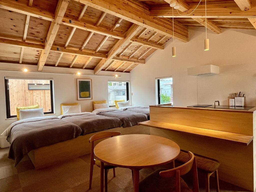 a living room with four beds and a table at ESPLANADE VILLAGE HOTEL b in Kamakura