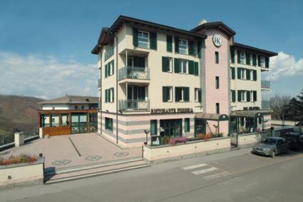 a large building with a clock on it on a street at Hotel Kristall in Monghidoro