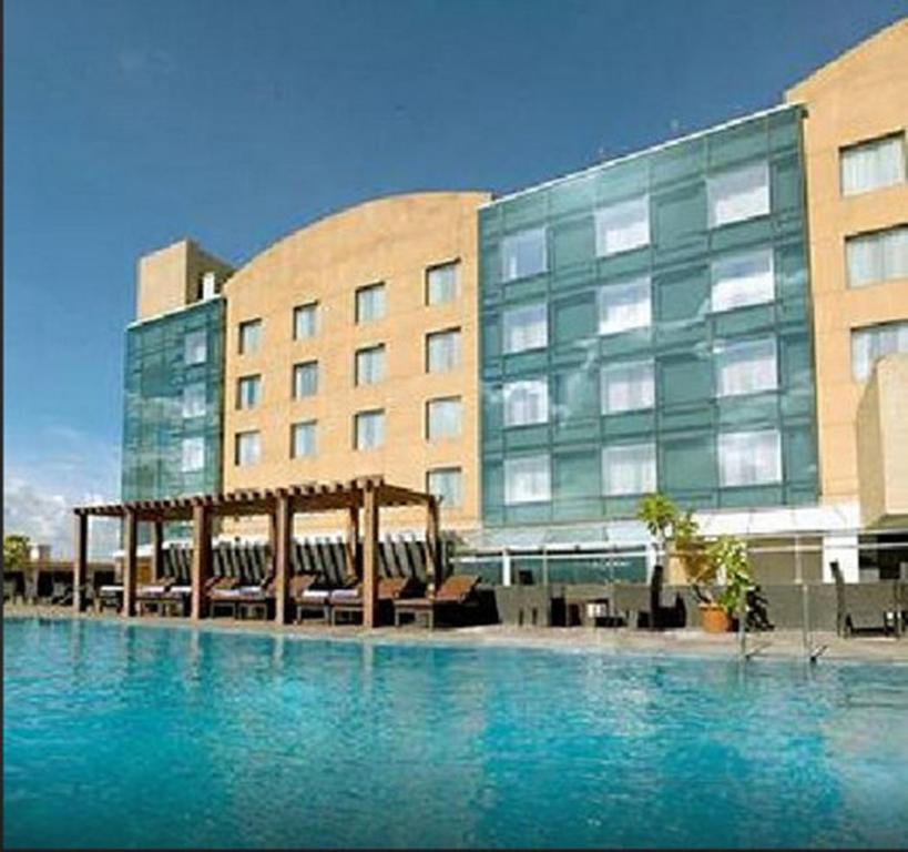 a large swimming pool in front of a building at Royal Orchid Central, Pune in Pune