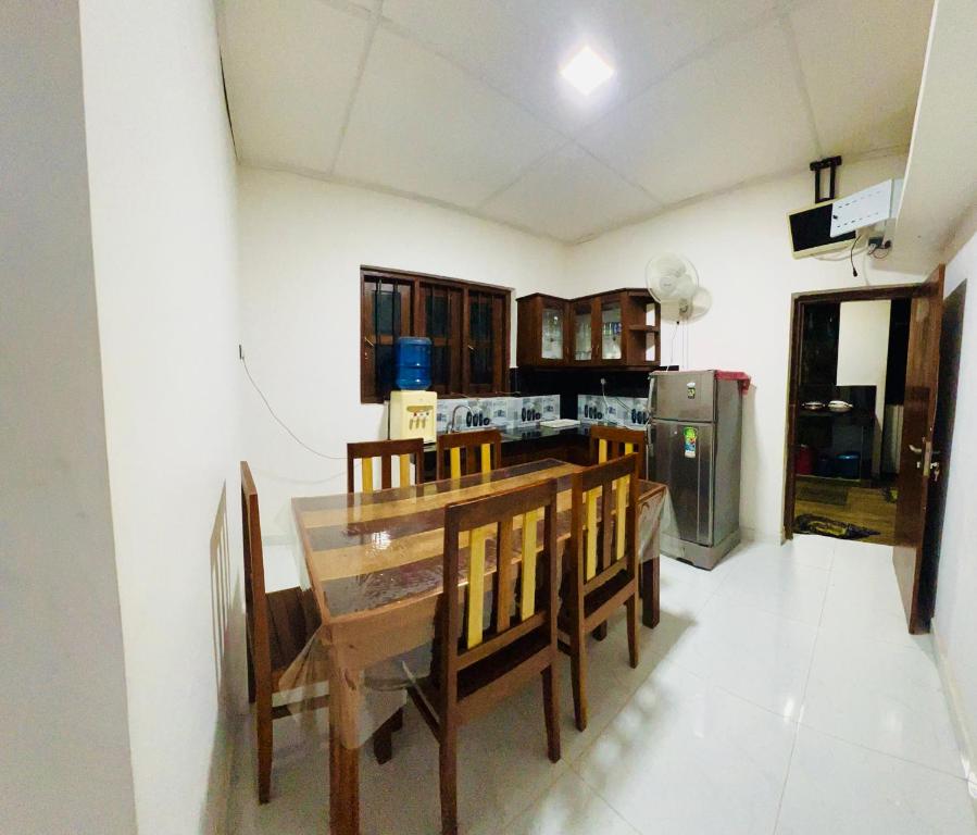 PolatagamaPolatagama Jungle Eco Resort的配有桌椅和冰箱的厨房