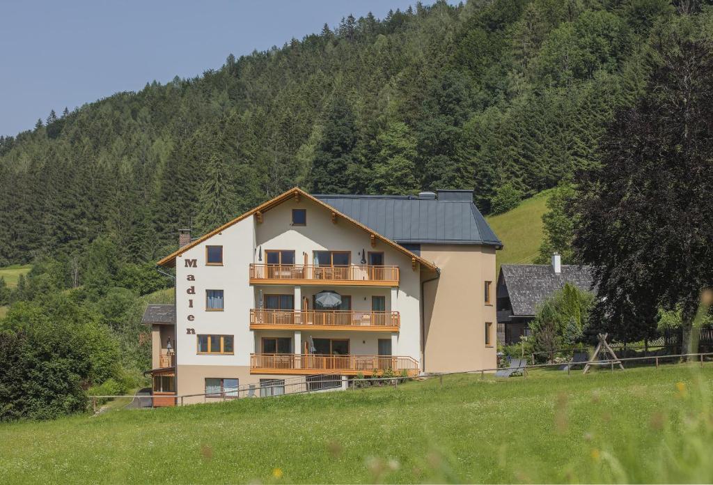 a large house on a hill in a field at Appartementhaus Madlen in Hinterstoder
