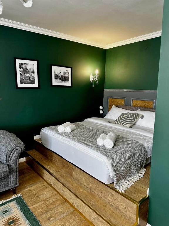 a bedroom with a large bed with green walls at LUX-Апартаменты London Style в центре Усть-Каменогорска in Ustʼ-Kamenogorsk