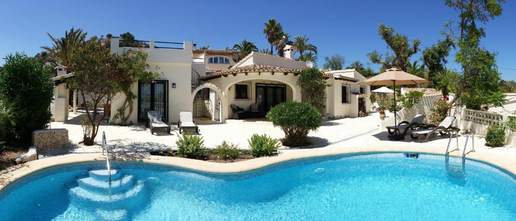 een groot zwembad voor een huis bij CASA CHOULOU Moraira in Moraira