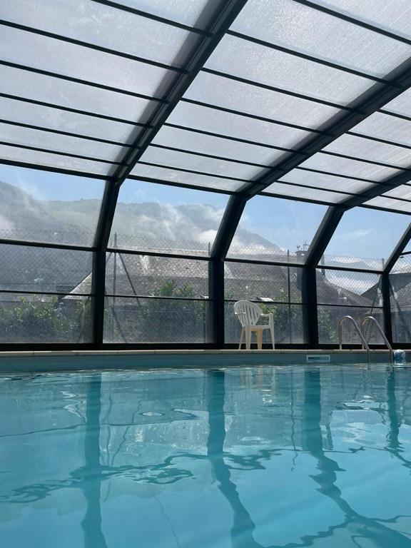 - une piscine avec une chaise et une vue sur les montagnes dans l'établissement ArriuMage, à Bielle