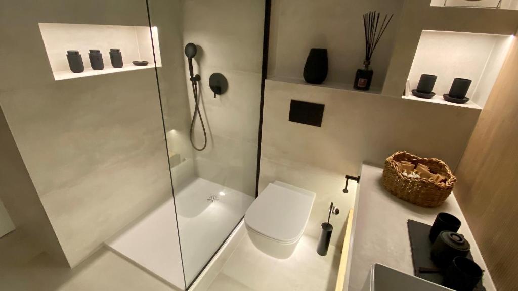 a white bathroom with a shower and a toilet at Up&Above ,New Luxury Apt, Steps from Beach and Old Town in Hvar