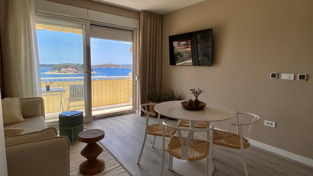 a living room with a table and a view of the ocean at Up&Above ,New Luxury Apt, Steps from Beach and Old Town in Hvar