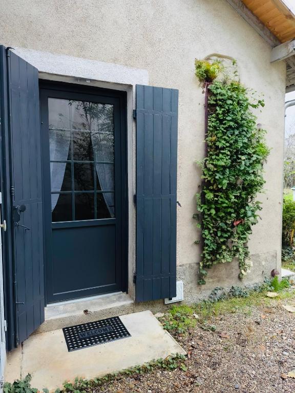 une porte bleue sur le côté d'une maison dans l'établissement La Maison de Romance d’Hauterive, à Villeneuve-sur-Lot