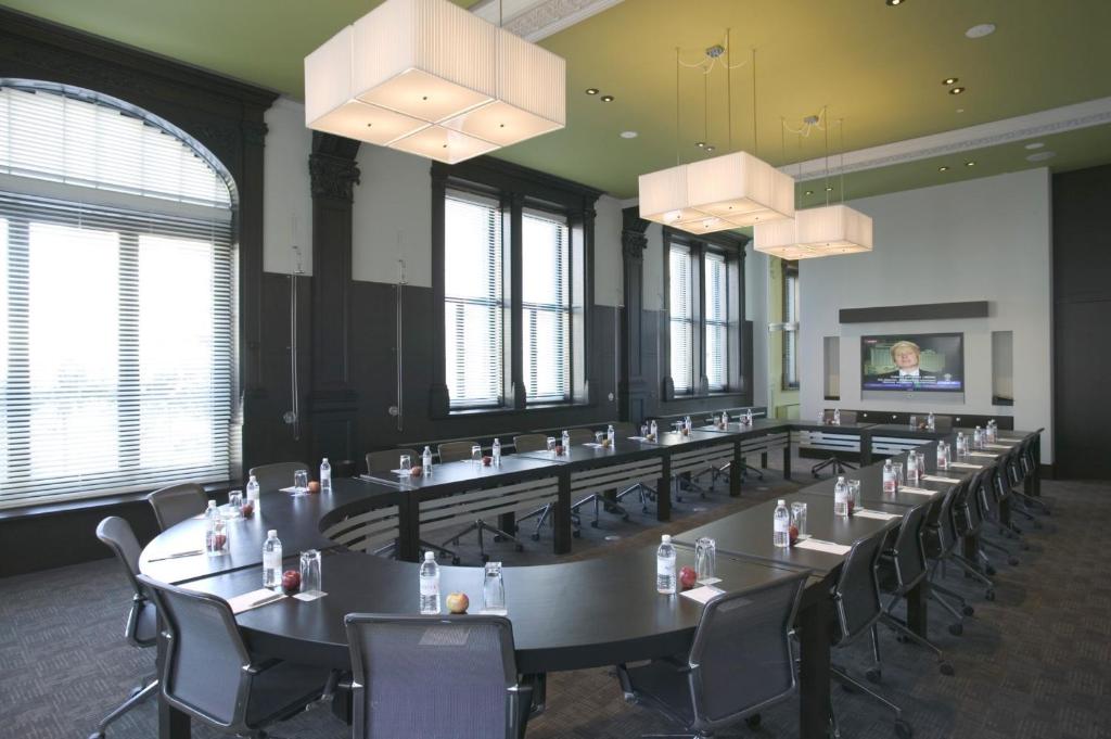 a large room with tables and chairs and windows at Hôtel Le Germain Québec in Quebec City