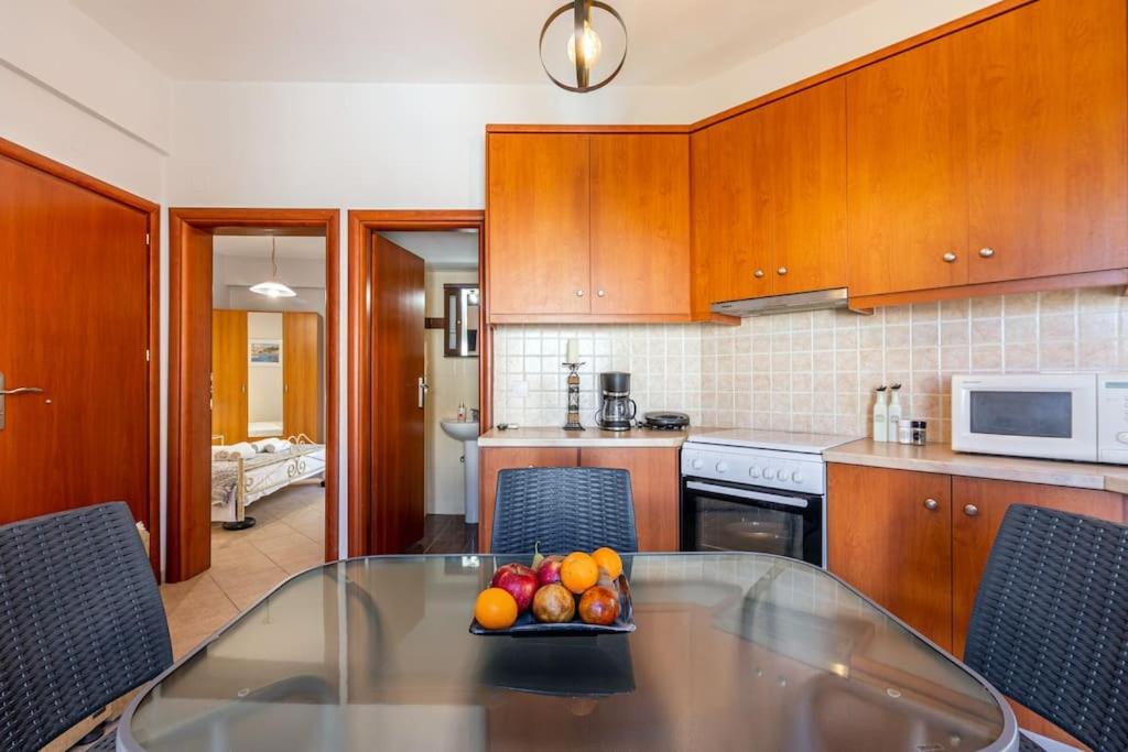 a kitchen with a table with a bowl of fruit on it at Niko's Stone House 2 in Tsoútsouros