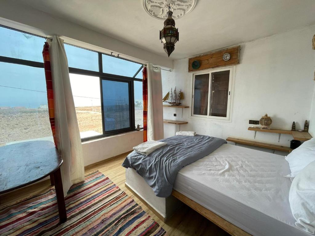 une chambre avec un lit et une grande fenêtre dans l'établissement EL Faro Surfstay, à Tamri
