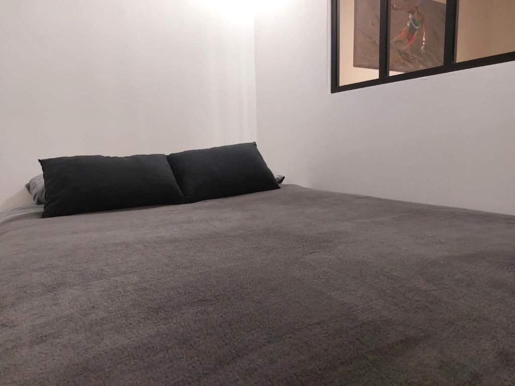 ジェクスにあるAppartement Cosy Parking Gratuitの白い部屋(黒い枕のベッド付)