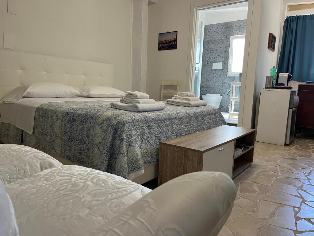 una camera da letto con due letti con asciugamani sopra di B&B Villa Mediterranea with parking space a Trani