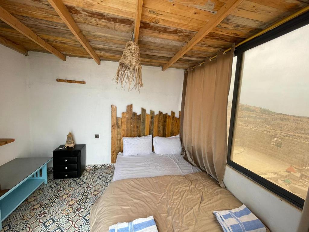 a bed in a room with a window at EL Faro Surfstay in Tamri