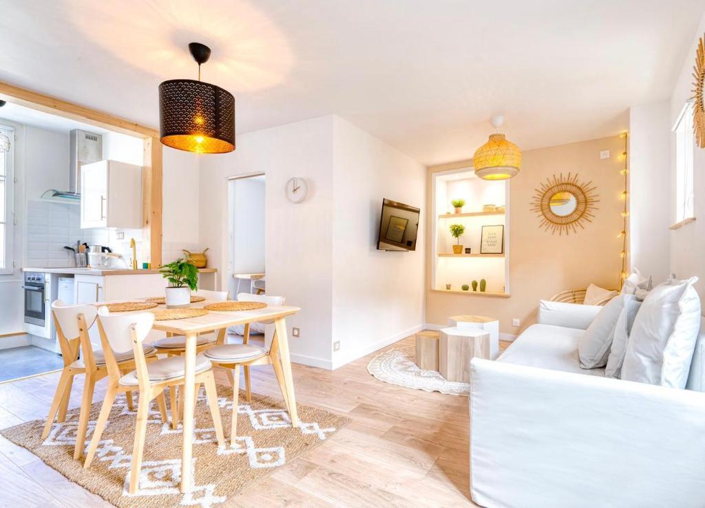 a kitchen and living room with a table and chairs at Le petit coin de la rue Basse in Caen
