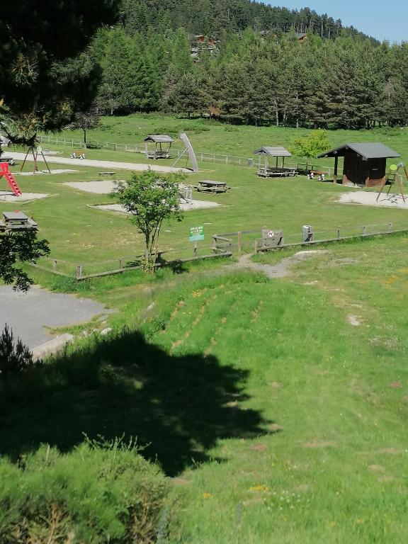 un parc avec une aire de jeux avec des tables de pique-nique dans l'herbe dans l'établissement Duplex au coeur des Pyrénées, à Bolquère-Pyrénées 2000