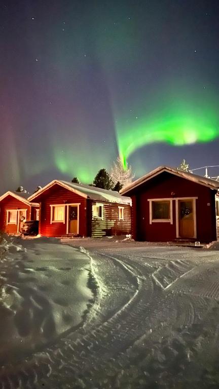a house with the aurora in the sky at Lapland Arctic Cabins in Kemijärvi