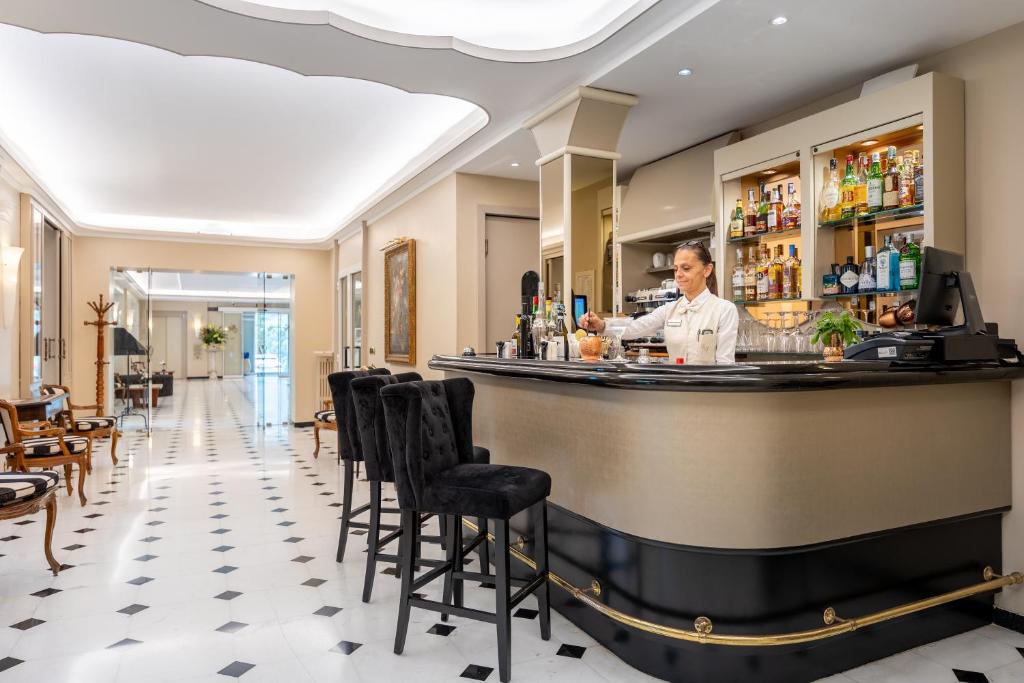 a man standing behind a bar in a restaurant at Hotel Metropole in Santa Margherita Ligure