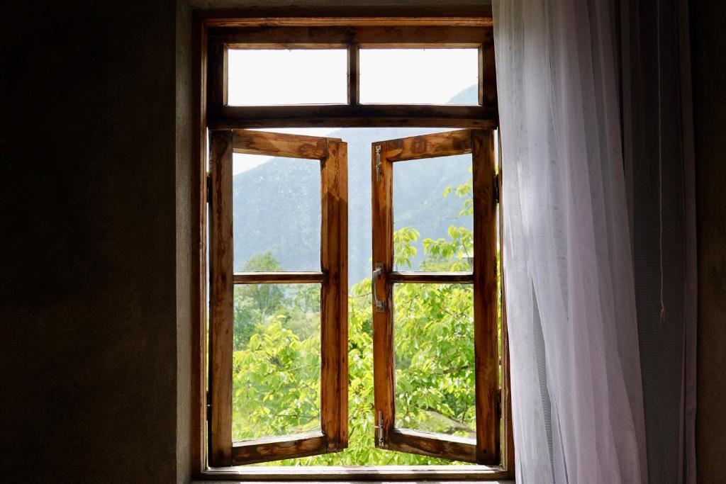 an open window with a white curtain and trees at Maikostan in Shuakhevi
