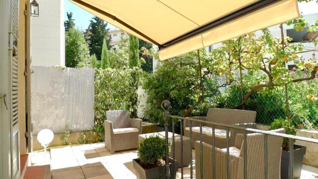 un patio extérieur avec des chaises et un parasol dans l'établissement Maison CENTRE CANNES 2 CHAMBRES 4 COUCHAGES, à Cannes
