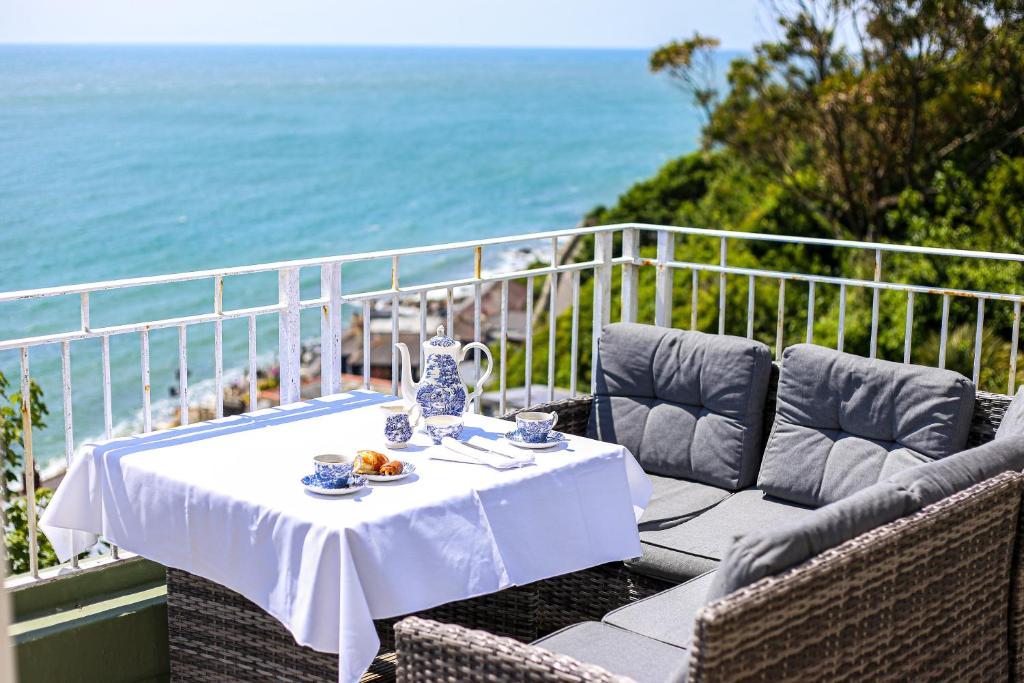 a table and chairs on a balcony with the ocean at The Wellington Hotel in Ventnor