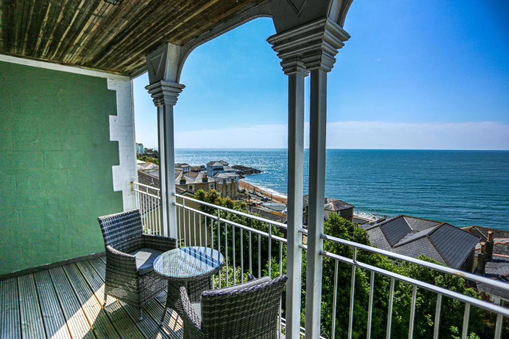 a balcony with a table and chairs and the ocean at The Wellington Hotel in Ventnor