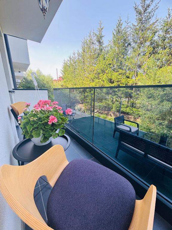 a balcony with a purple ottoman and a balcony with a view at Golden Apartament in Şelimbăr