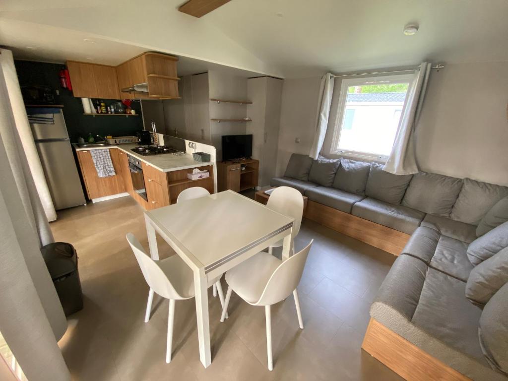 une cuisine et un salon avec une table et des chaises dans l'établissement Mobil Home - Camping Les Oyats 4 étoiles, à Seignosse
