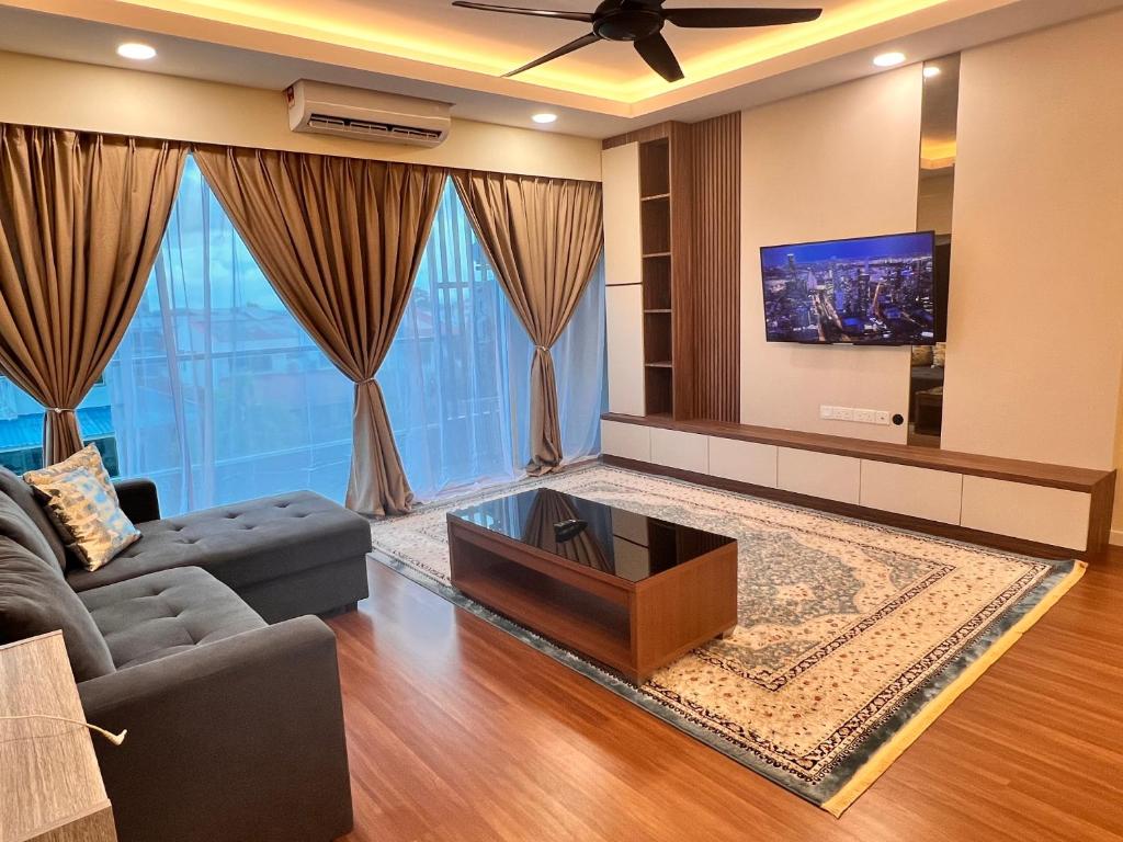 Hermosa Homestay في لاهاد داتو: غرفة معيشة مع أريكة وتلفزيون